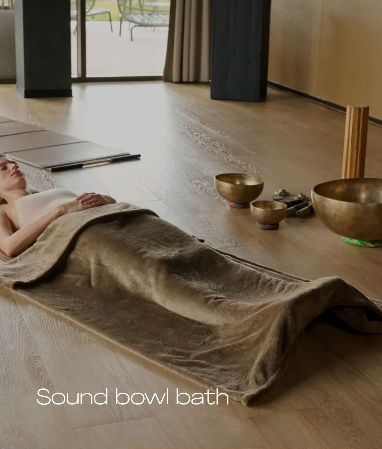 Guest resting beside singing bowls at Melea